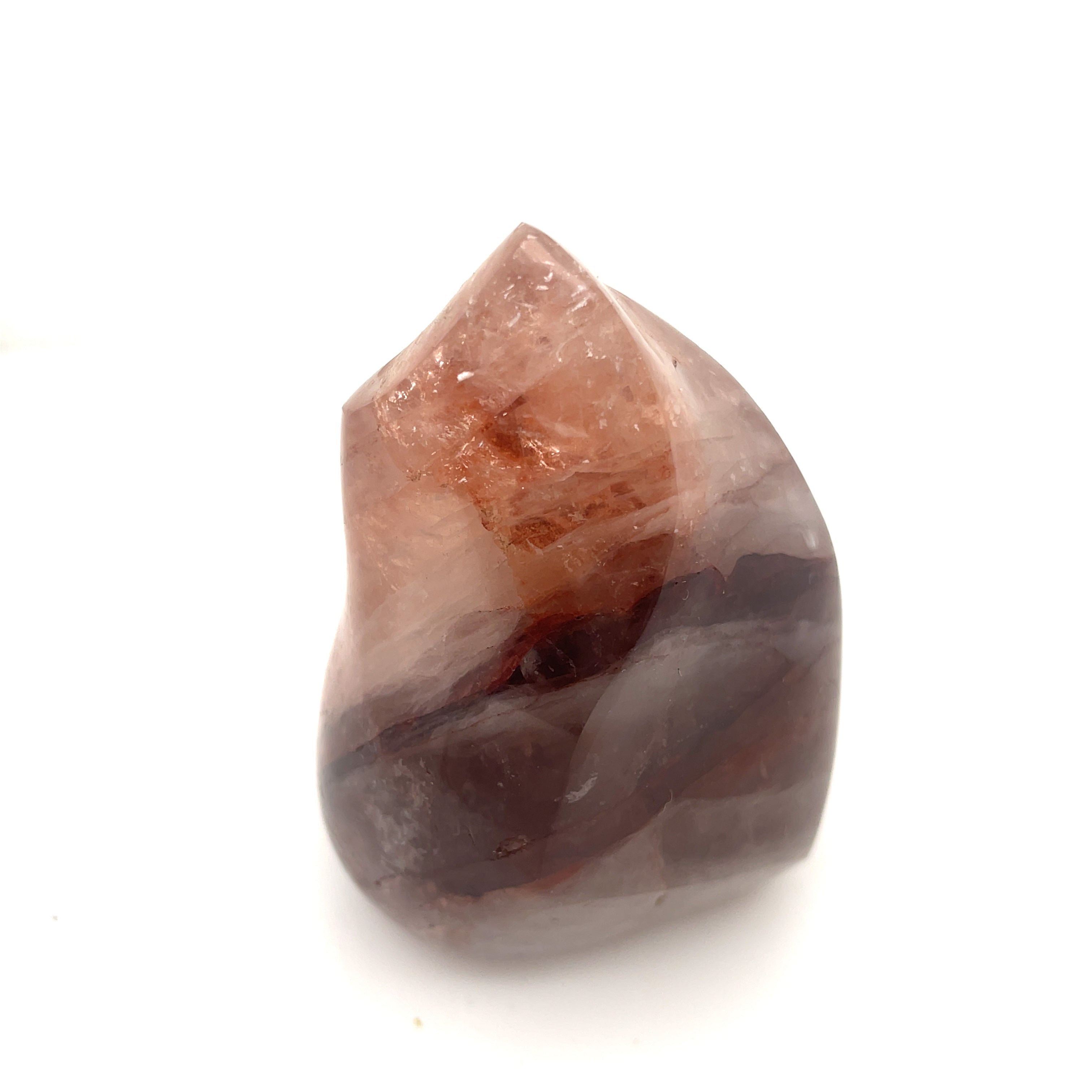 A polished Fire Quartz gemstones with a flame-like carving and a pink to red gradient on a white background front overview.