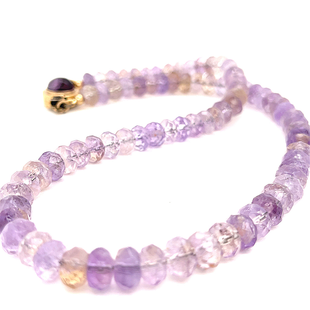 A purple ametrine beaded gemstone necklace with a gold-filled fluorite box clasp in a long, overview on a white background. 