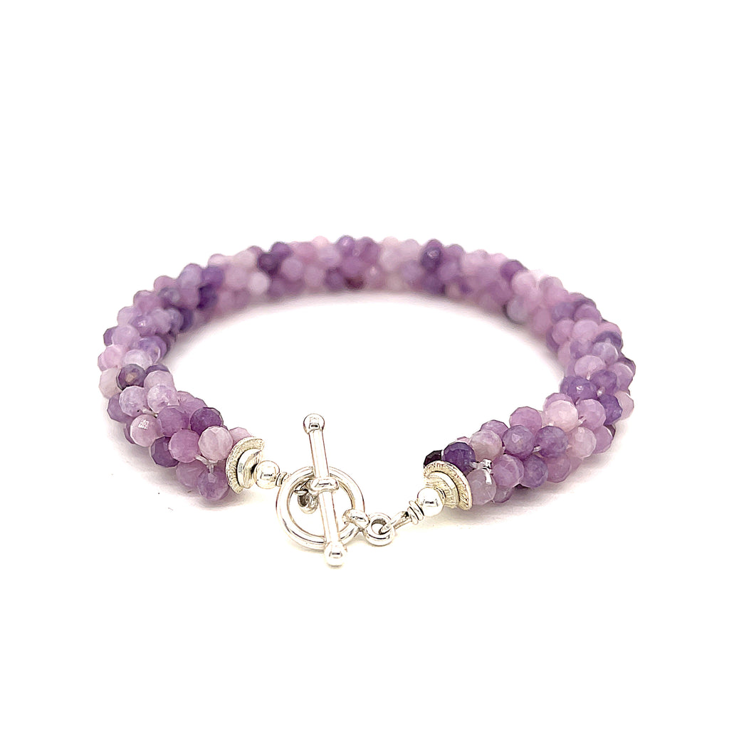 A purple sugilite gemstone bracelet with a sterling silver simple circle toggle, crocheted into a tubular pattern on a white background, toggle overview. 