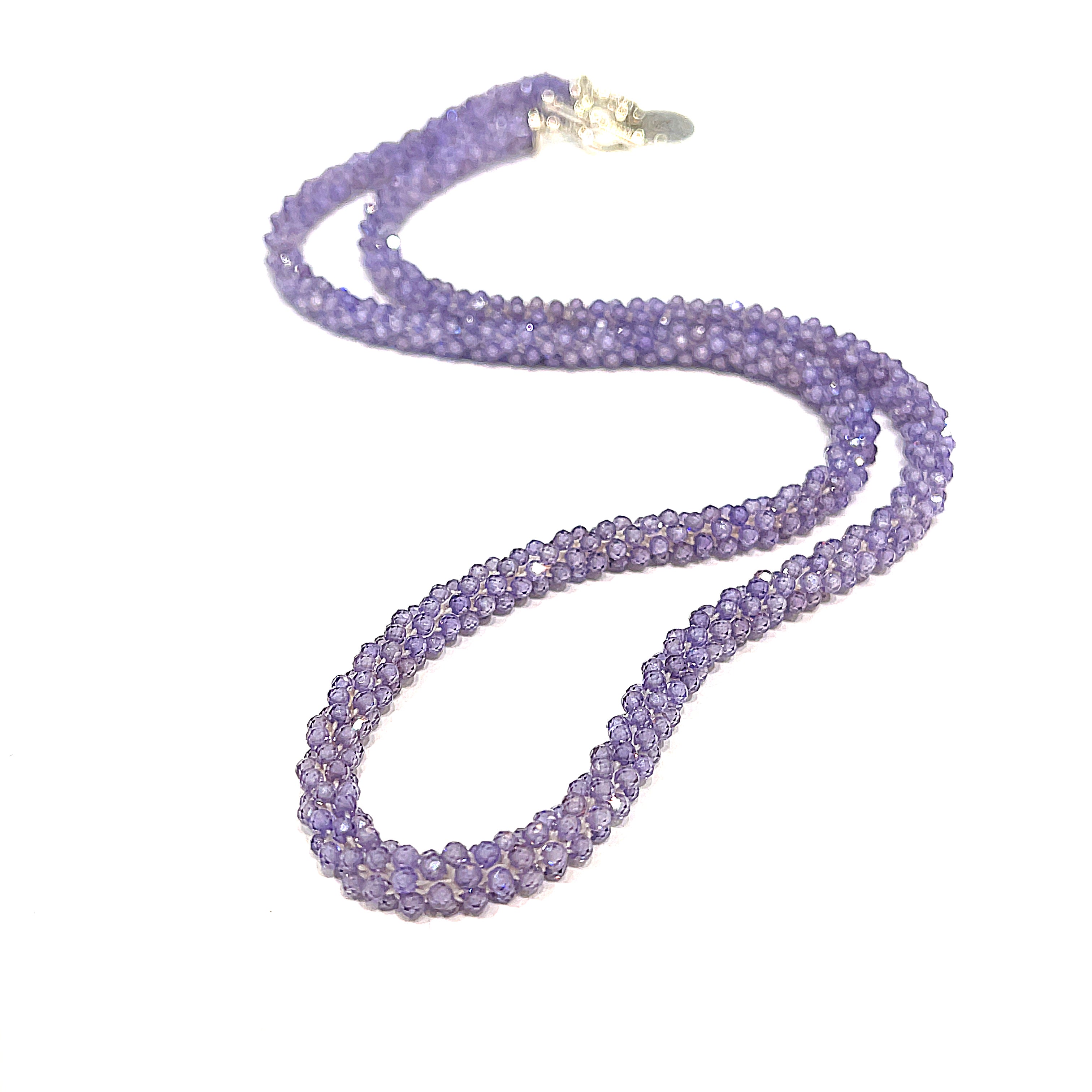 A purple zircon gemstone crocheted necklace with a sterling silver toggle, on a white background. A long front overview. 