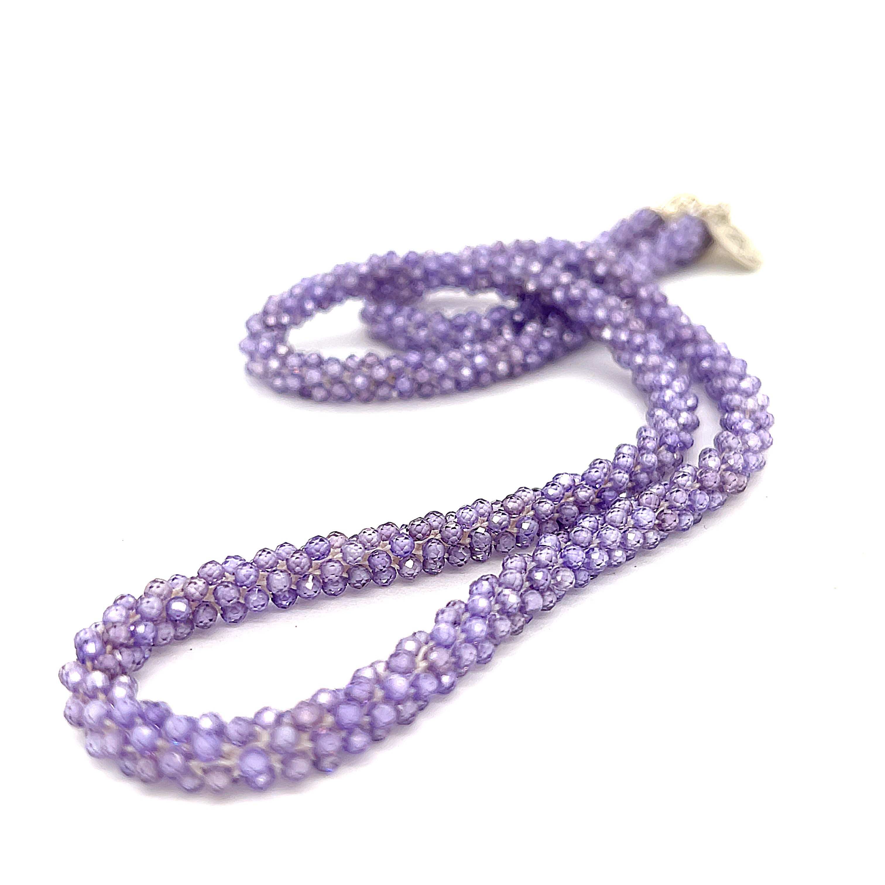 A purple zircon gemstone crocheted necklace with a sterling silver toggle, on a white background. A long front slight left diagonal overview. 