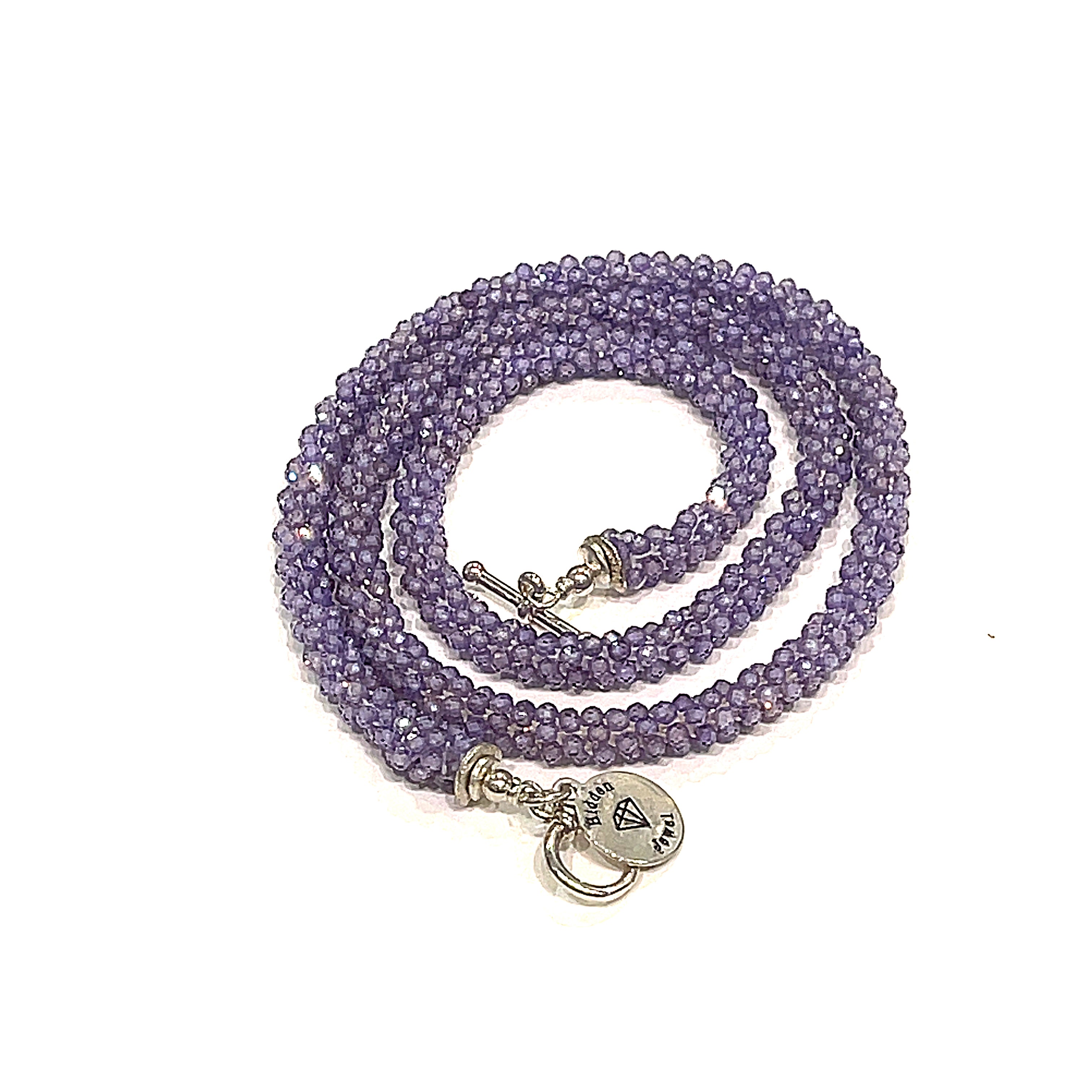 A purple zircon gemstone crocheted necklace with a sterling silver toggle, on a white background. A spiral overview. 