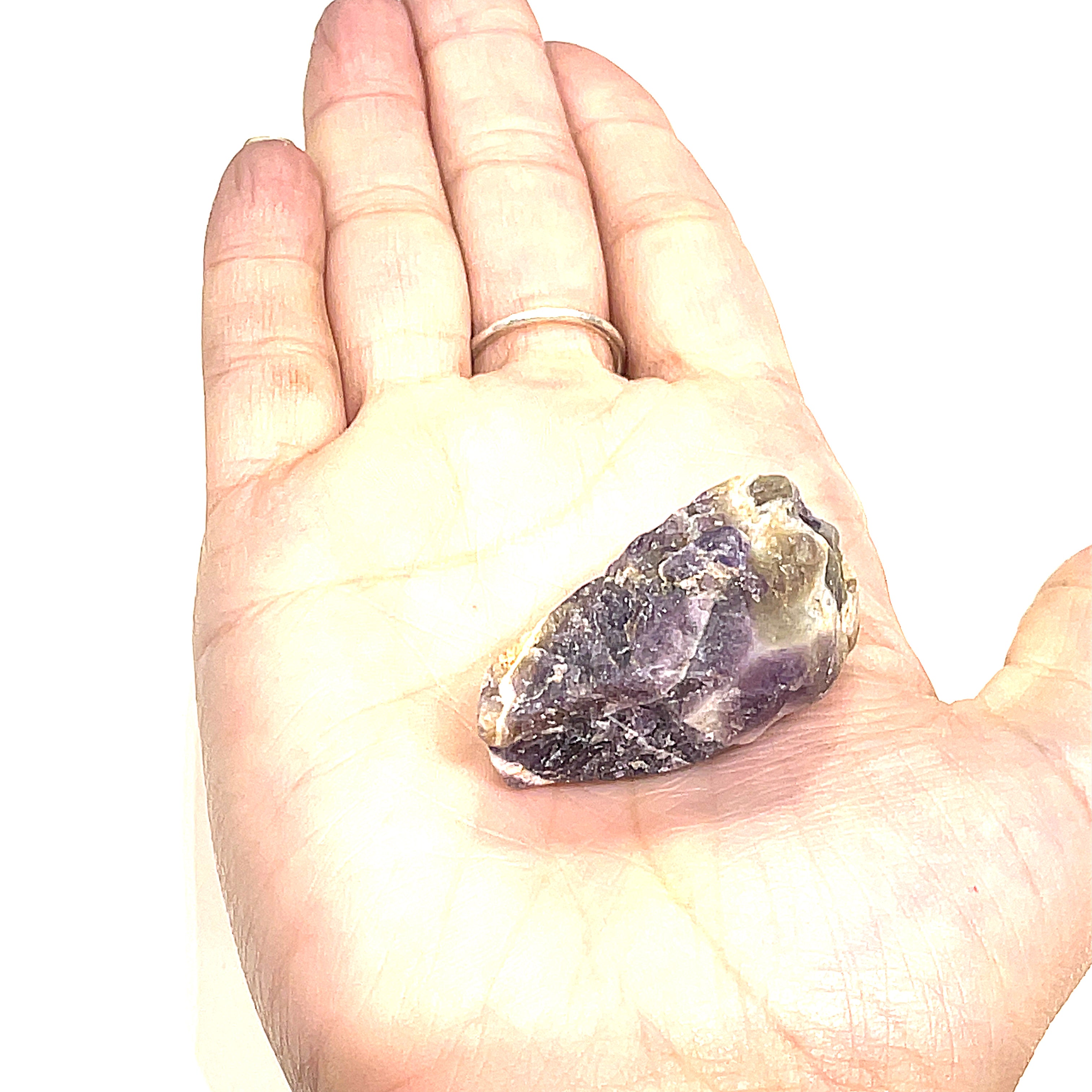 A  raw Amethyst or Prasiolite gemstones on a white background, on a models palm, front overview.