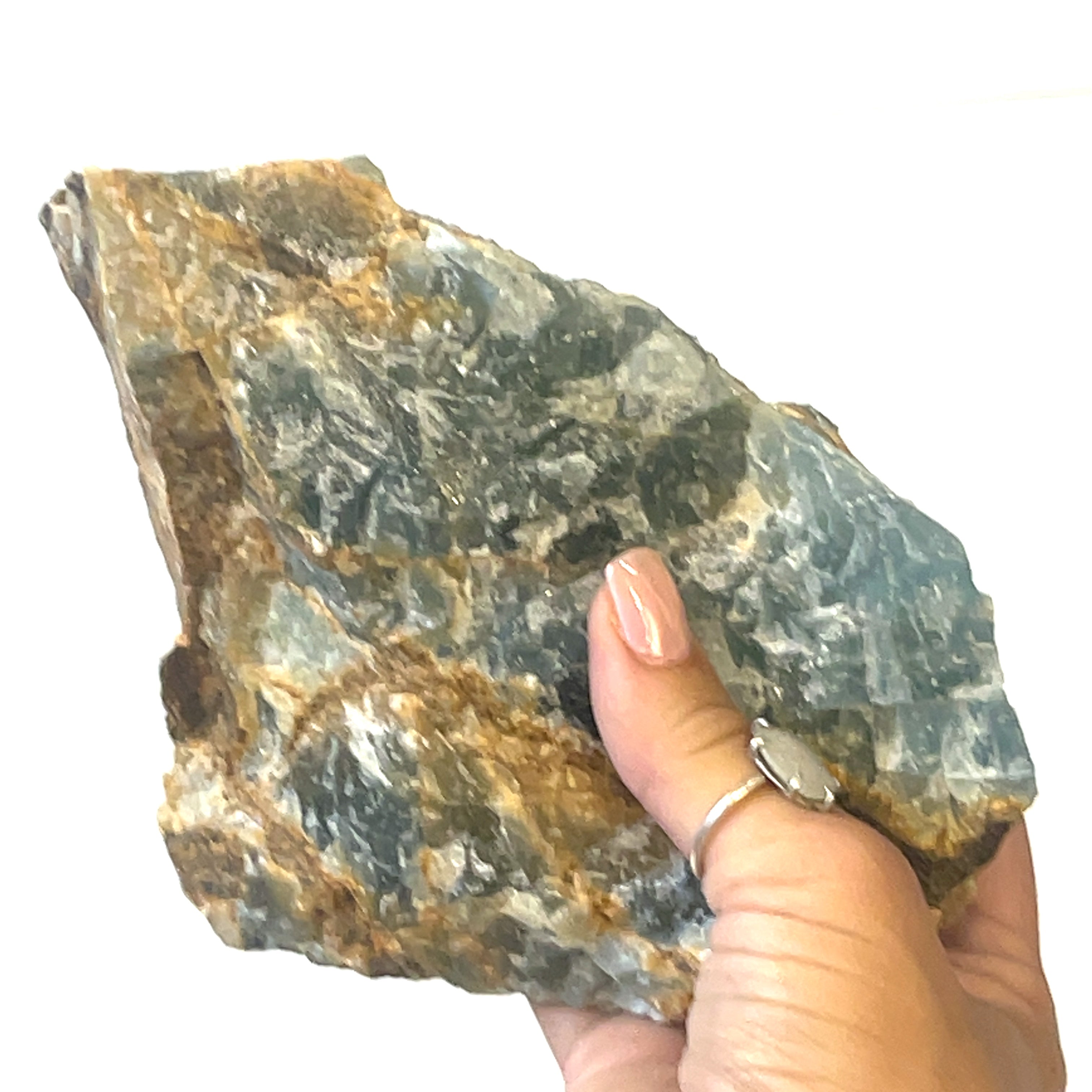 A raw Blue Onyx gemstone with a rough, uncut surface showing shades of blue and brown (11275g) in a models hand on a white background, front view. 
