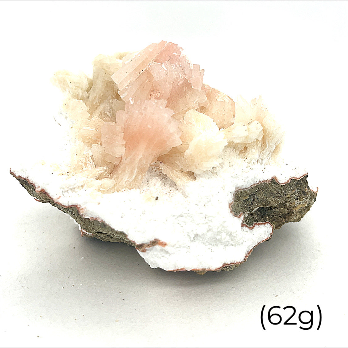 A raw cluster of pink heulandite on mordenite gemstone, with a label indicating its weight as 62 grams on a white background front overview. 