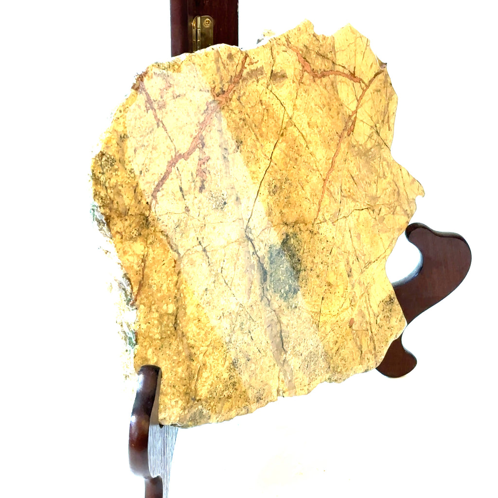 A raw slab gemstone of Copper in Matrix displayed on a wooden stand, with a polyurethane coating on one side, on a white background, and in a front  right angle view.