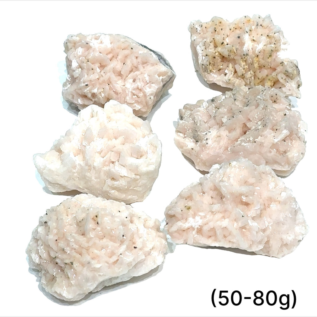 A raw specimen of Pink Dolomite with Chalcopyrite, showing a rough, crystalline texture with specks of color on a white background, in a close-up view (50-80g)