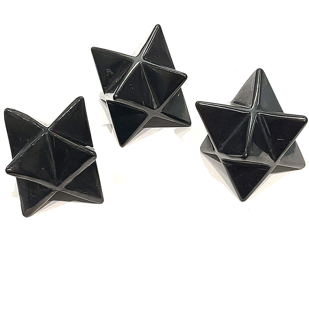 A set of three black Shungite gemstone merkaba carvings displayed against a white background, front overview. 