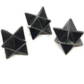 A set of three black Shungite gemstone merkaba carvings displayed against a white background, front overview. 