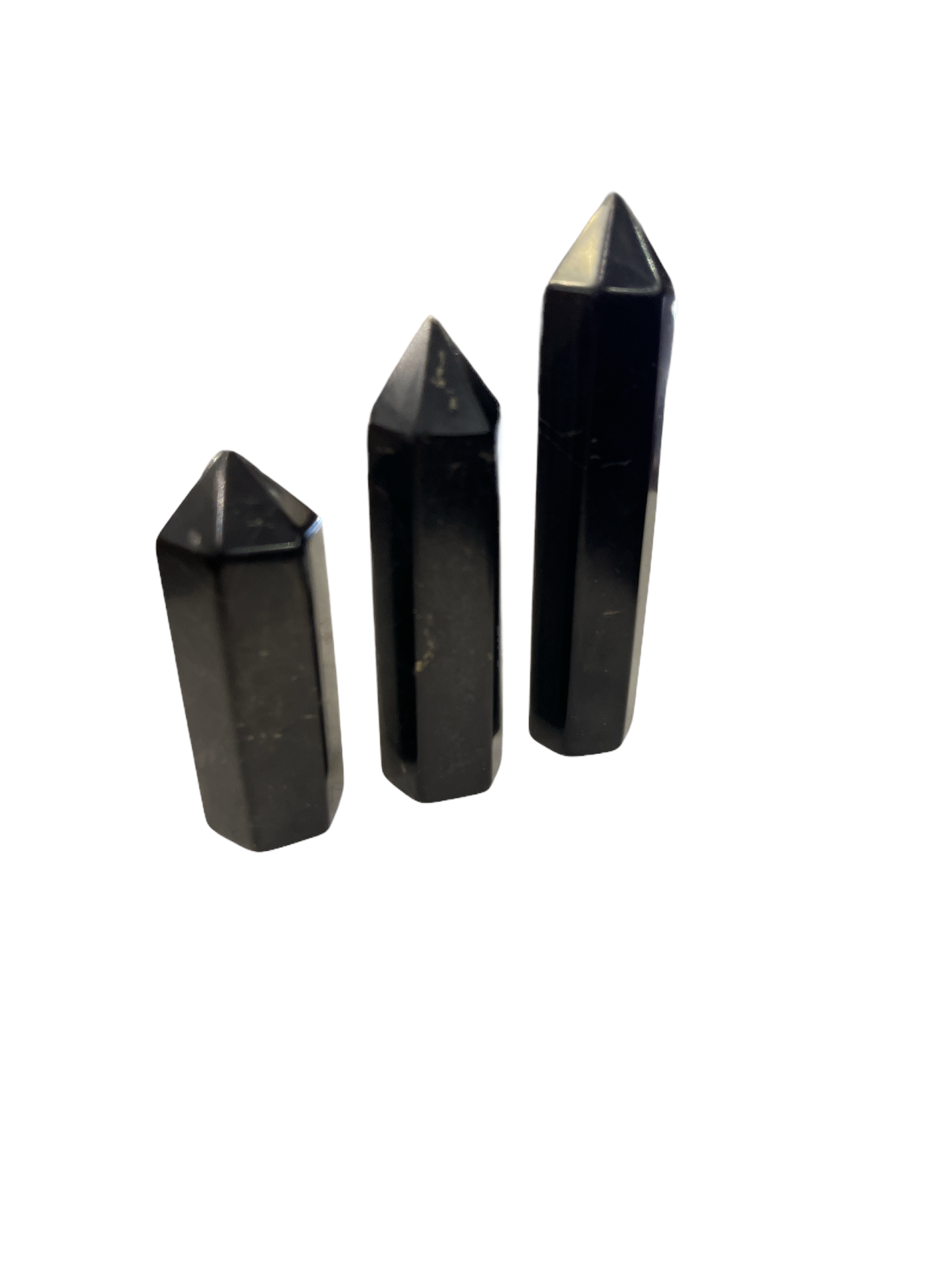 A set of three black Shungite gemstone towers of varying sizes arranged in a line on a white background, front overview.
