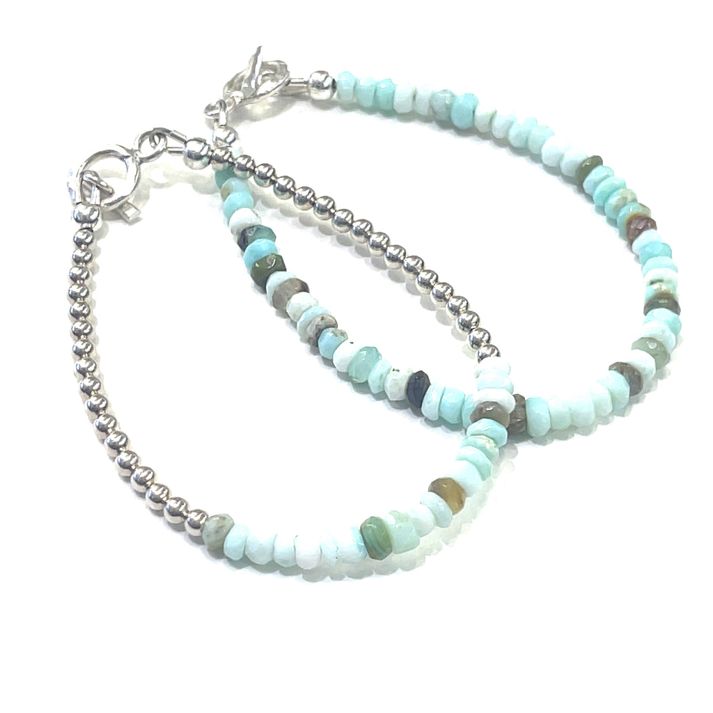 A set of two Blue Opal gemstone bracelet with sterling silver toggle handmade by Hidden Jewel on a white background slight right angled overview.