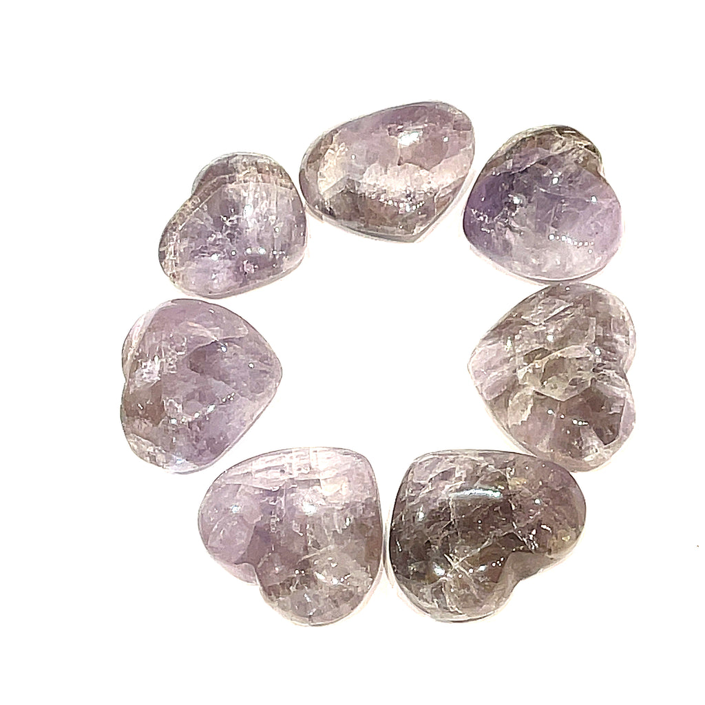 A small group of Super Seven gemstone heart carving, in a circle for a close-up, overview on a white background.