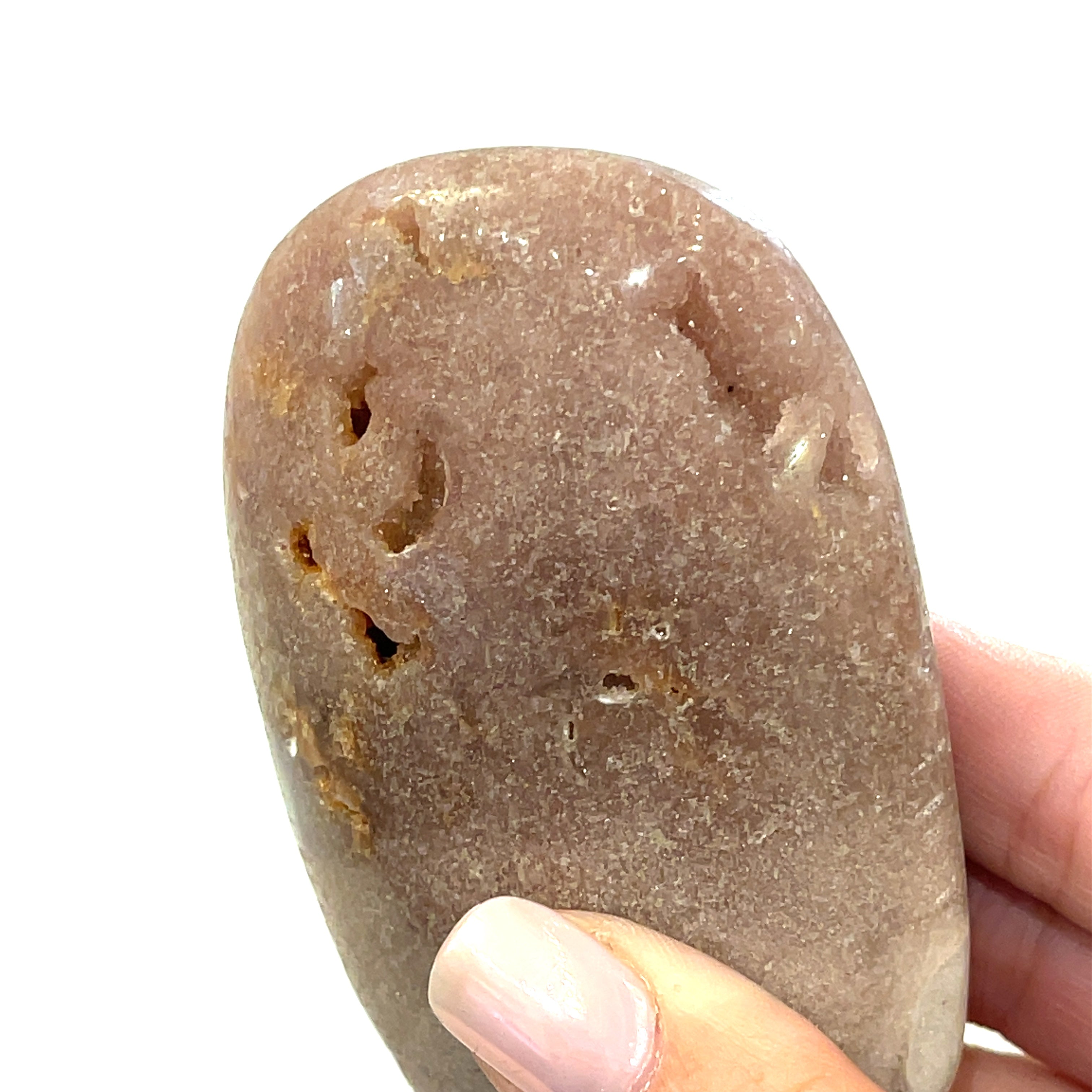 A smooth, polished Pink Amethyst gemstone with a rounded shape, displaying its natural purple color on a white background front overview in a models hand.
