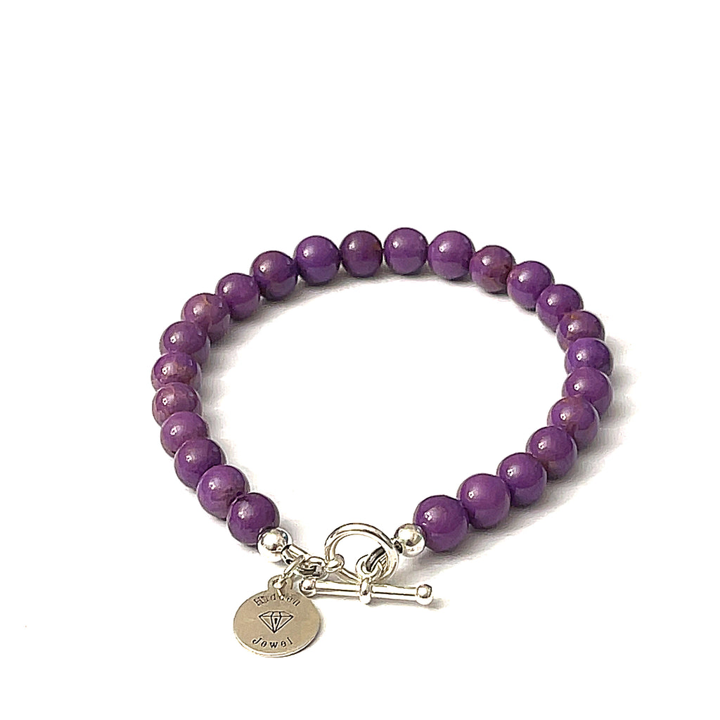 A sterling silver bracelet featuring a series of purple Phosphosiderite gemstones, with a toggle clasp, on a white background, back overview. 