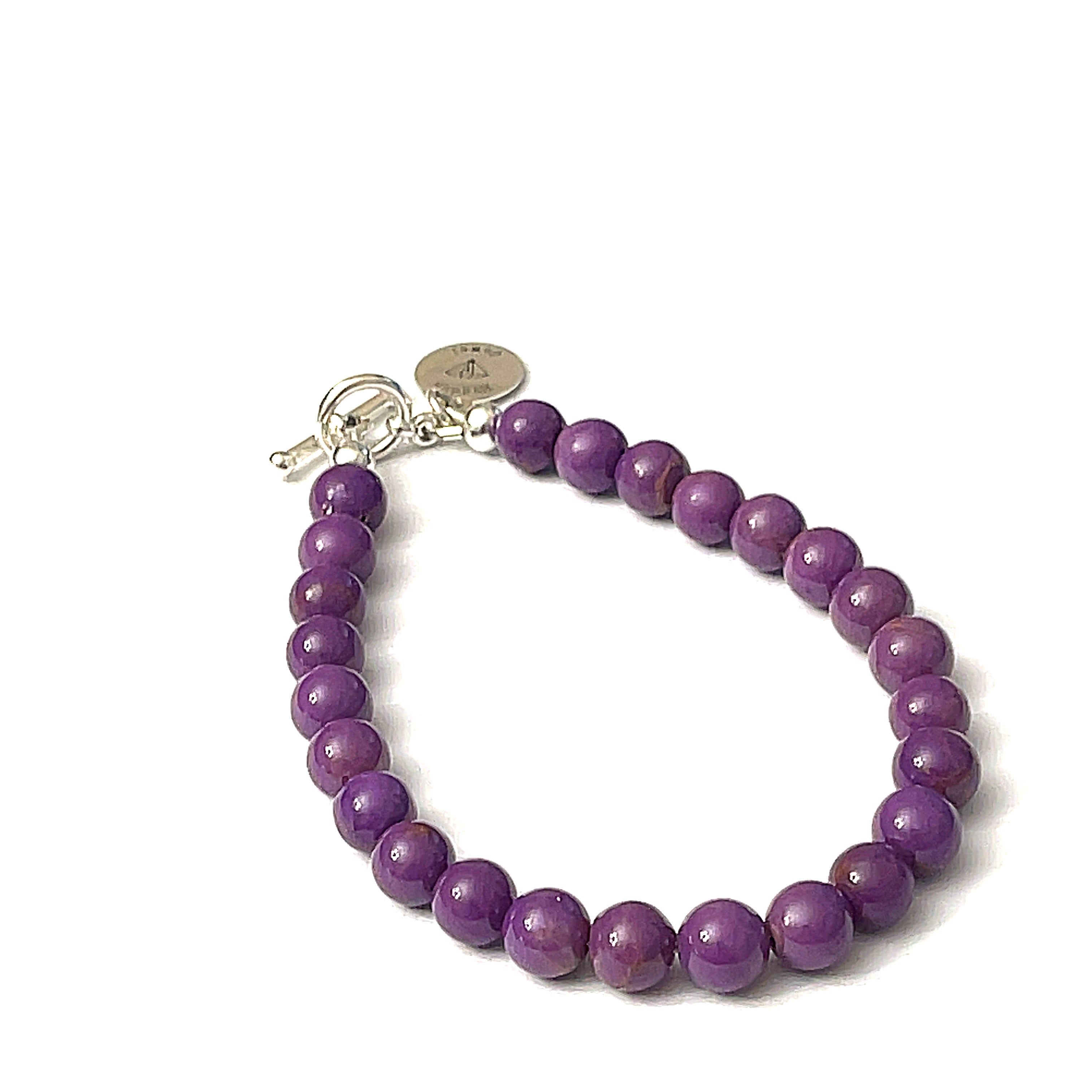 A sterling silver bracelet featuring a series of purple Phosphosiderite gemstones, with a toggle clasp, on a white background, front overview. 