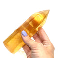 A third Honey Calcite gemstone tower displayed on a white background, front view.