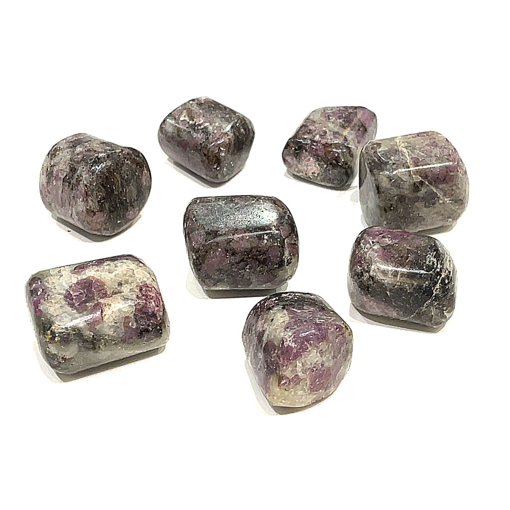 A tumbled Eudialyte gemstones with a purple and gray color palette on a white background, front overview. 