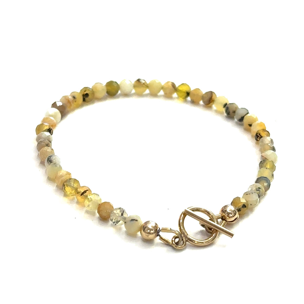 A yellow opal gemstone beaded bracelet with a gold-filled simple circle toggle, size 6.5. on a white background, back view