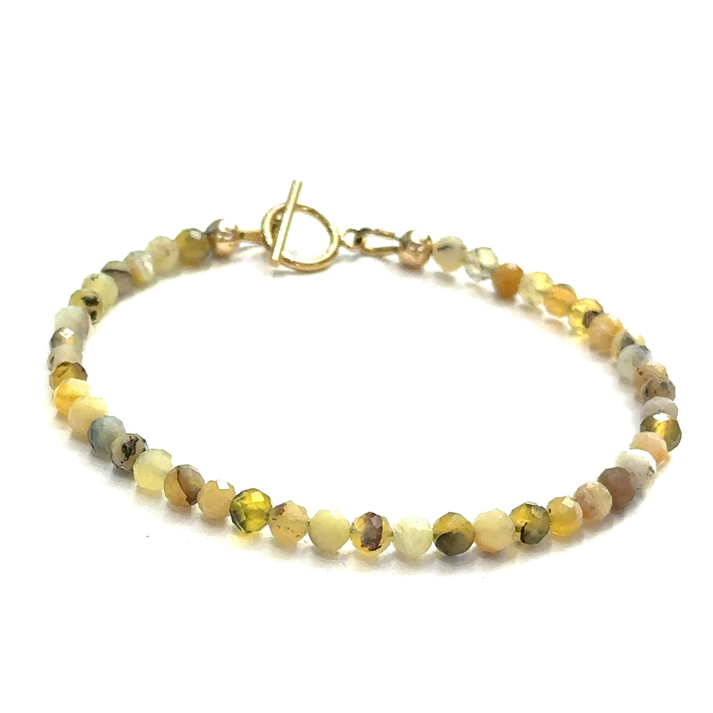 A yellow opal gemstone beaded bracelet with a gold-filled simple circle toggle, size 6.5. on a white background, front view