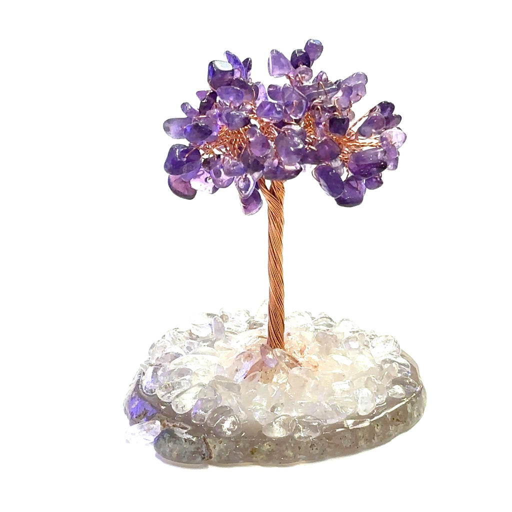 Amethyst Gemstone tree placed on an altar for home décor and energy healing. On a white background, front view.