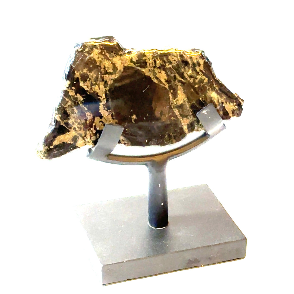 An Apache Gold slab gemstone with polyurethane on one side, displayed on a metal stand on a white background, front right angled view.