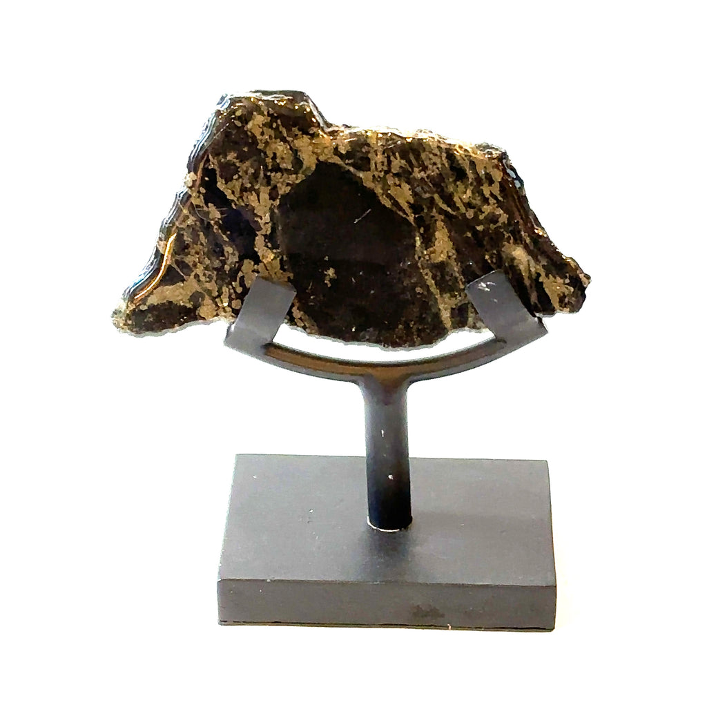 An Apache Gold slab gemstone with polyurethane on one side, displayed on a metal stand on a white background, front view.