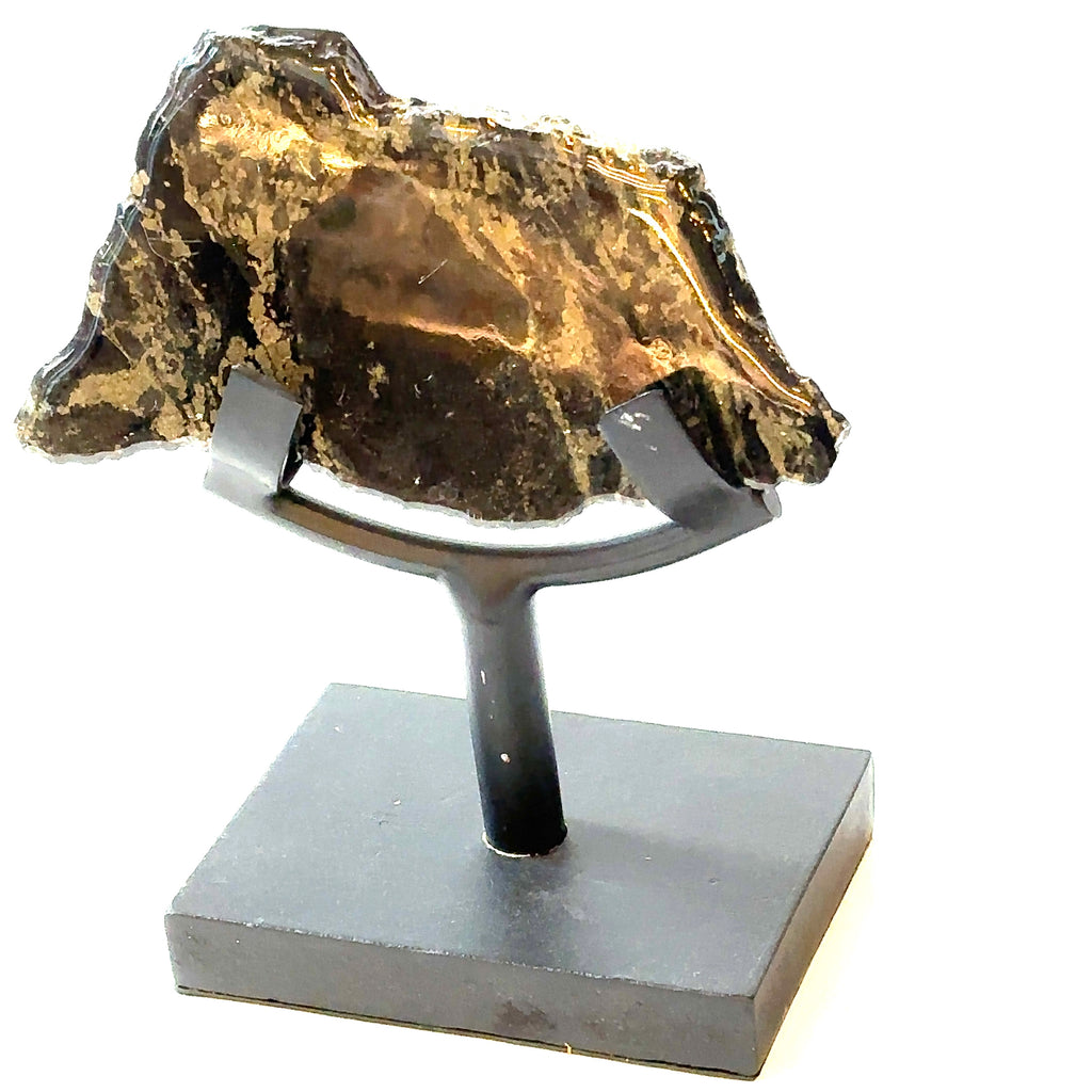 An Apache Gold slab gemstone with polyurethane on one side, displayed on a metal stand on a white background, in a close-up view of the front left angle.