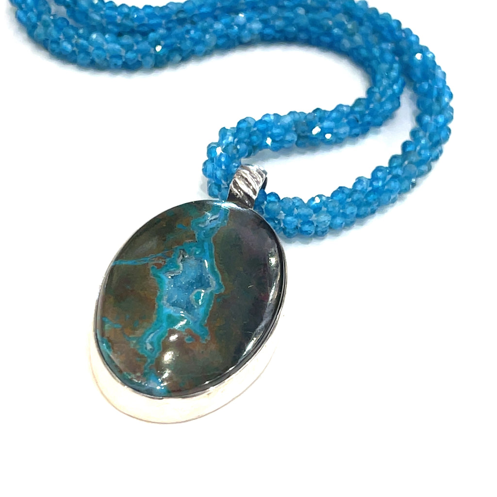 Blue Apatite crocheted gemstone necklace with Gem Silica Druzy pendant, handmade by Hidden Jewel on a white background, center angled overview