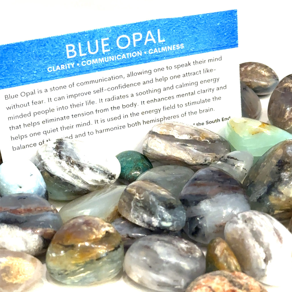Blue Opal gemstone showing natural soft blue hues and smooth polish with gemstone card on white background overview