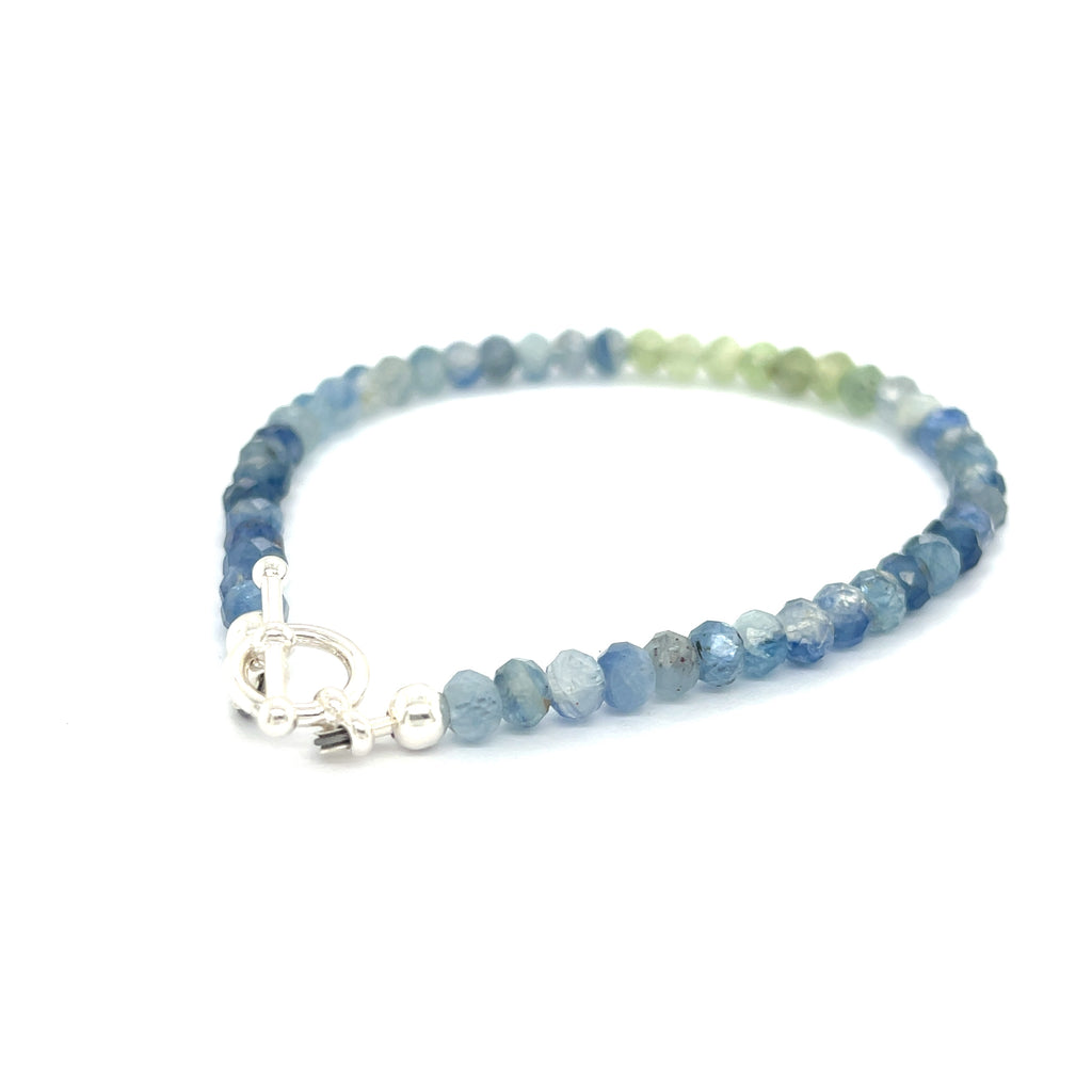 Blue and Green Kyanite faceted gemstone bracelet with sterling silver toggle on a white background back overview. 