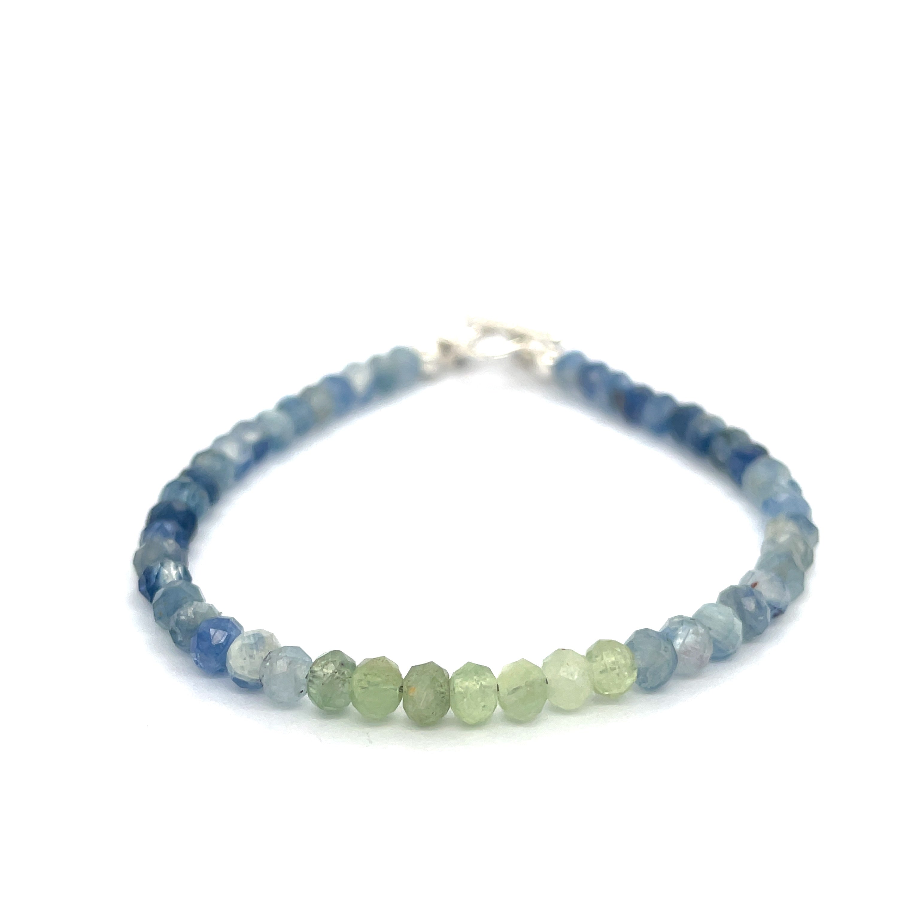 Blue and Green Kyanite faceted gemstone bracelet with sterling silver toggle on a white background front and center overview. 