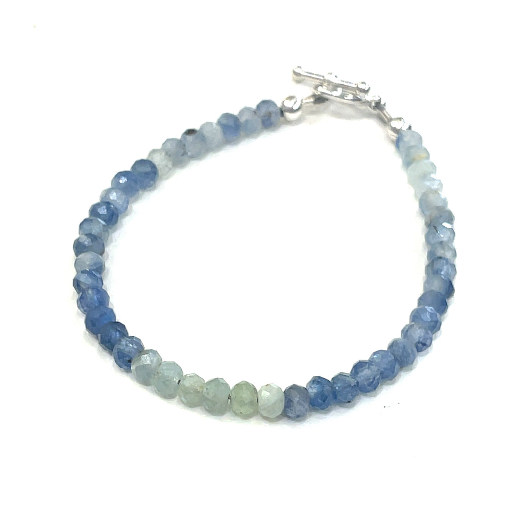 Blue and Green Kyanite faceted gemstone bracelet with sterling silver toggle on a white background front, close up overview.