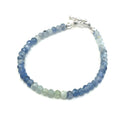 Blue and Green Kyanite faceted gemstone bracelet with sterling silver toggle on a white background front, close up overview.