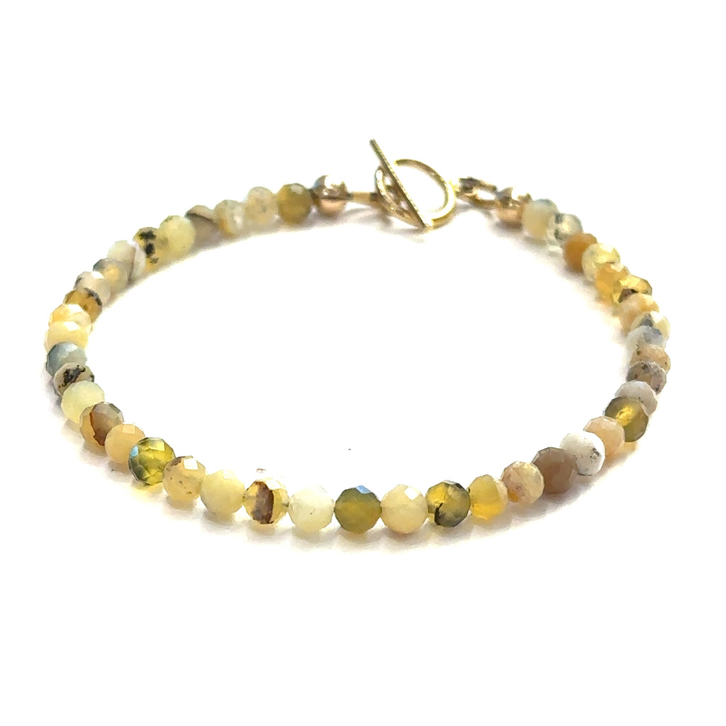 Close-up of 4mm faceted Yellow Opal beads showing natural yellow tones on a white background, front view