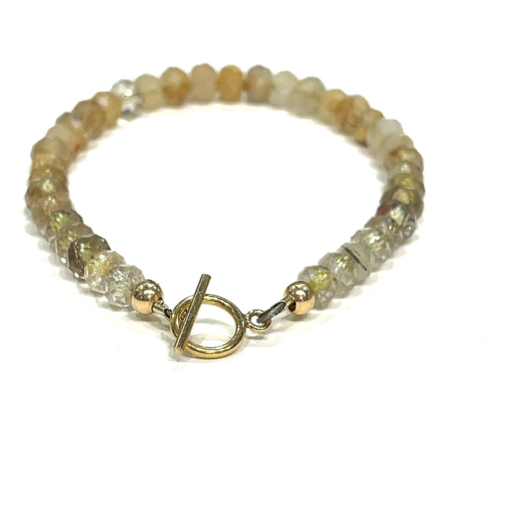 Close-up of 5mm faceted Golden Rutilated Quartz beads with visible golden inclusions on a white background, toggle overview. 