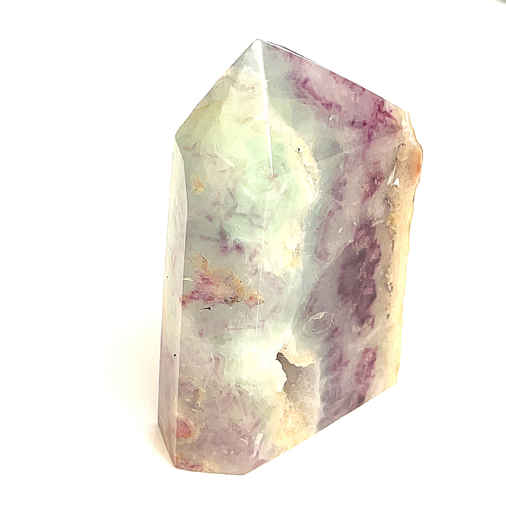 Close-up of Bluish green and purple Fluorite showing translucent layers a white background, front view. 