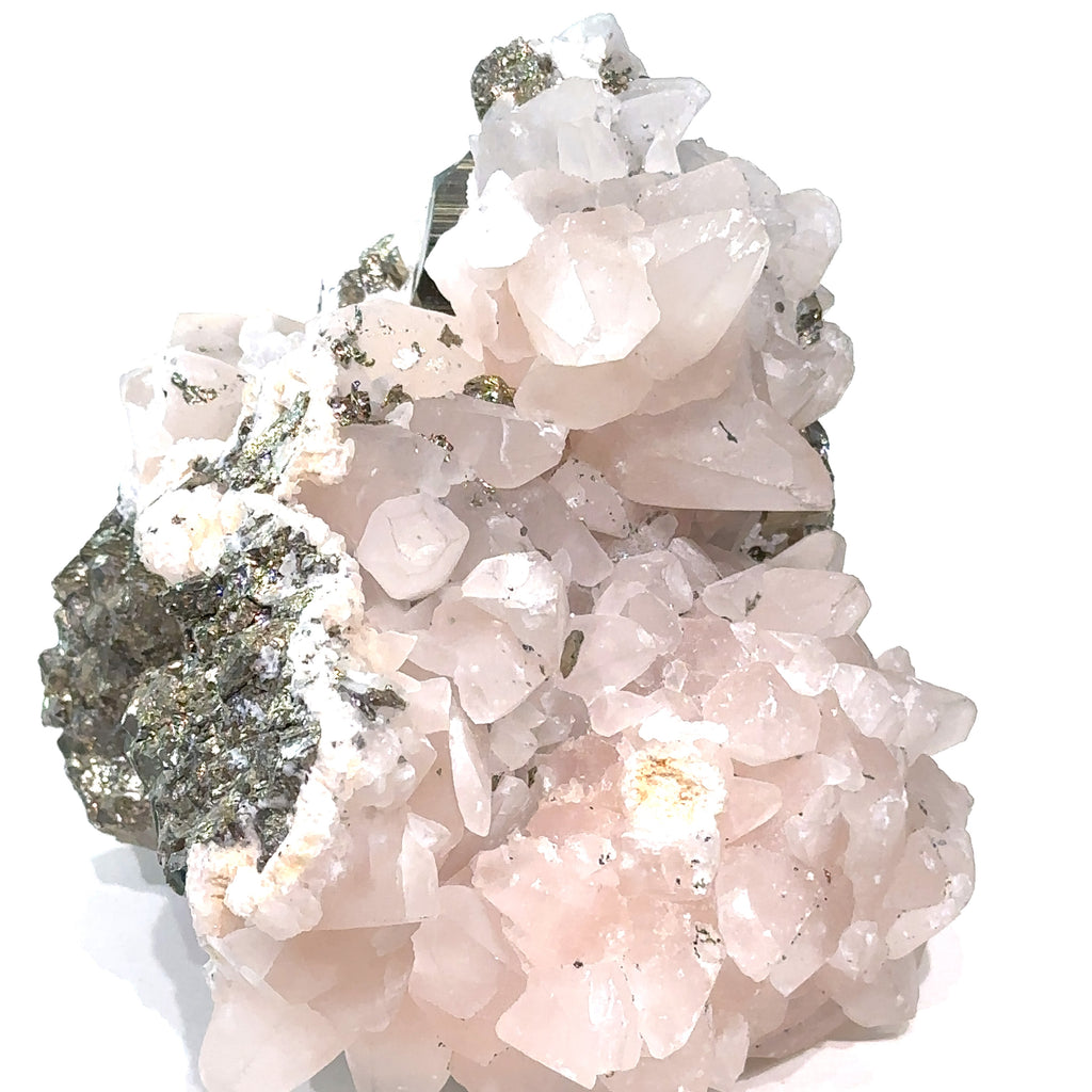 Close-up of Calcite and Fluorite crystal cluster with metallic Pyrite flecks on white background side view