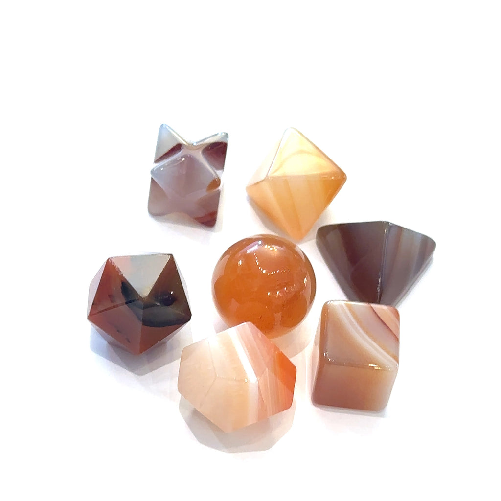 Close-up of Carnelian sacred geometry stones showing polished detail on white overview