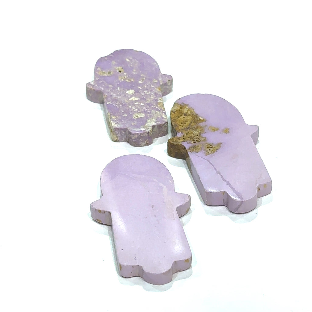 Close-up of Phosphosiderite Hamsa showing natural color variations in models hand on white background front view.