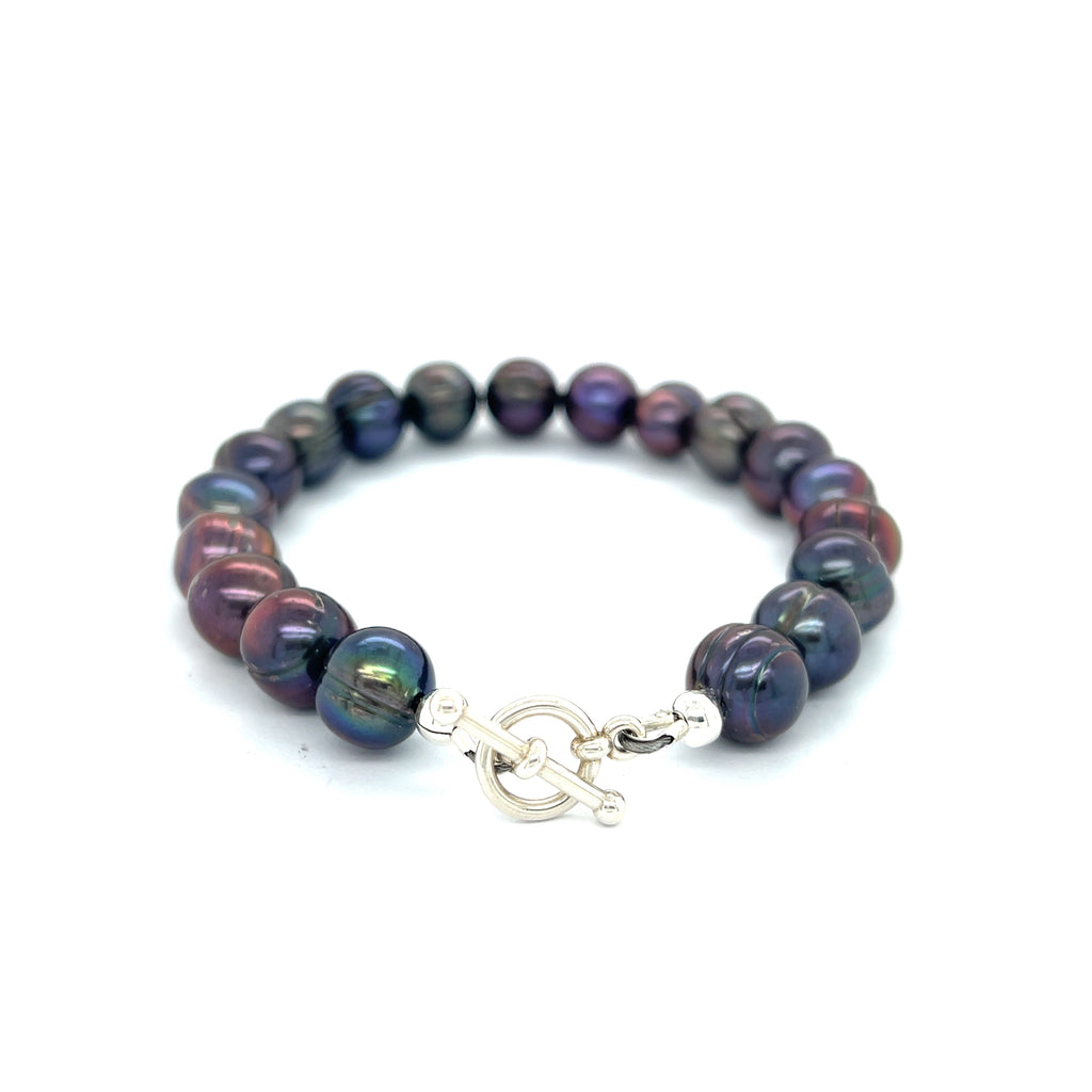 Close-up of Purple Freshwater Pearls showcasing luster and texture, handcrafted Boston jewelry on a white background back center overview.