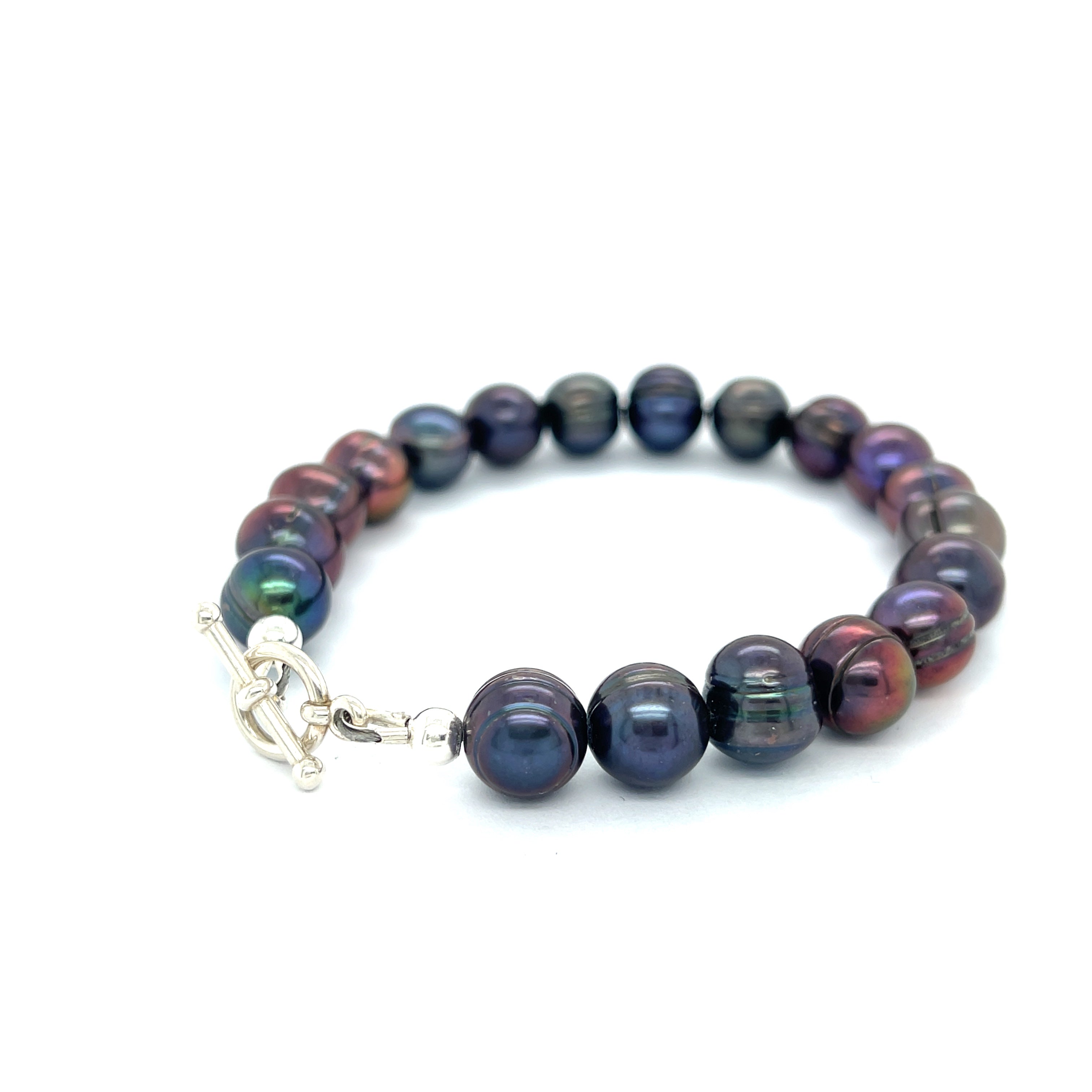 Close-up of Purple Freshwater Pearls showcasing luster and texture, handcrafted Boston jewelry on a white background back left angle overview.