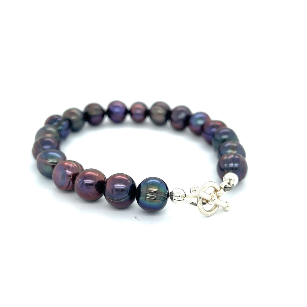 Close-up of Purple Freshwater Pearls showcasing luster and texture, handcrafted Boston jewelry on a white background back right angle overview.