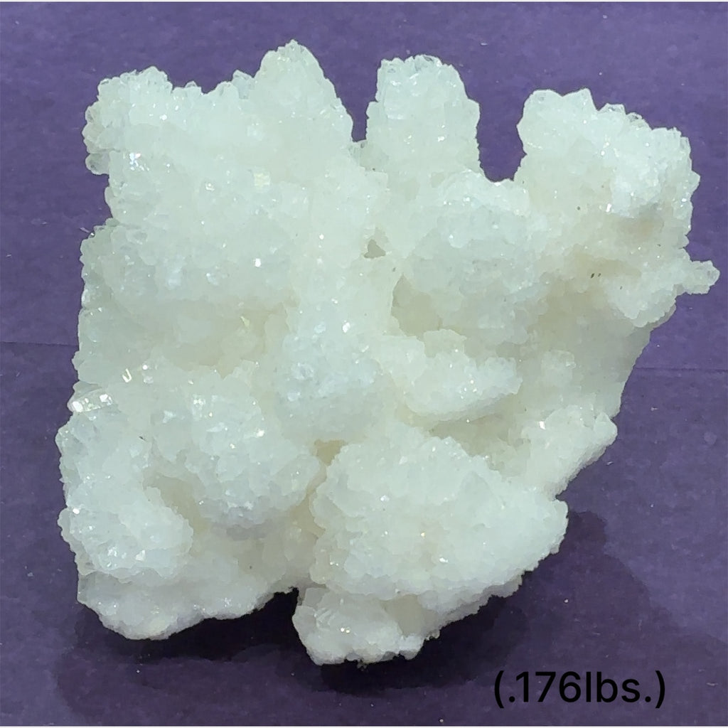 Close-up of White Aragonite cluster highlighting natural white crystal formations size (.176lbs.) on purple background front view.