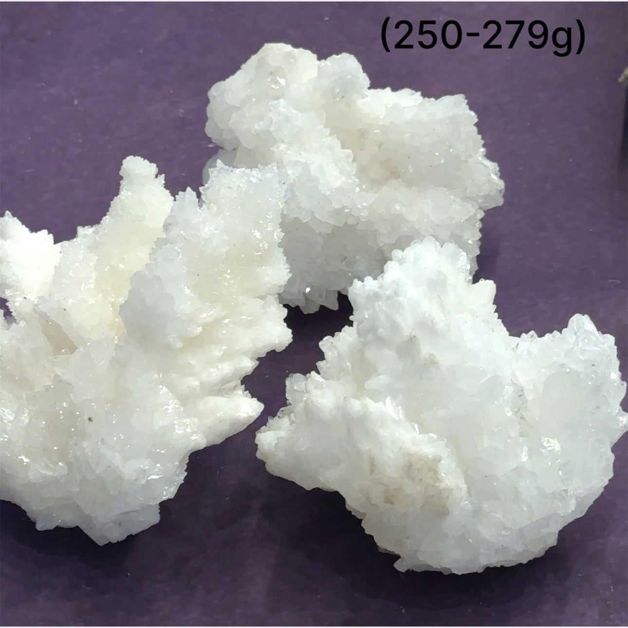 Close-up of White Aragonite cluster highlighting natural white crystal formations size (250-279g) on purple background front view.