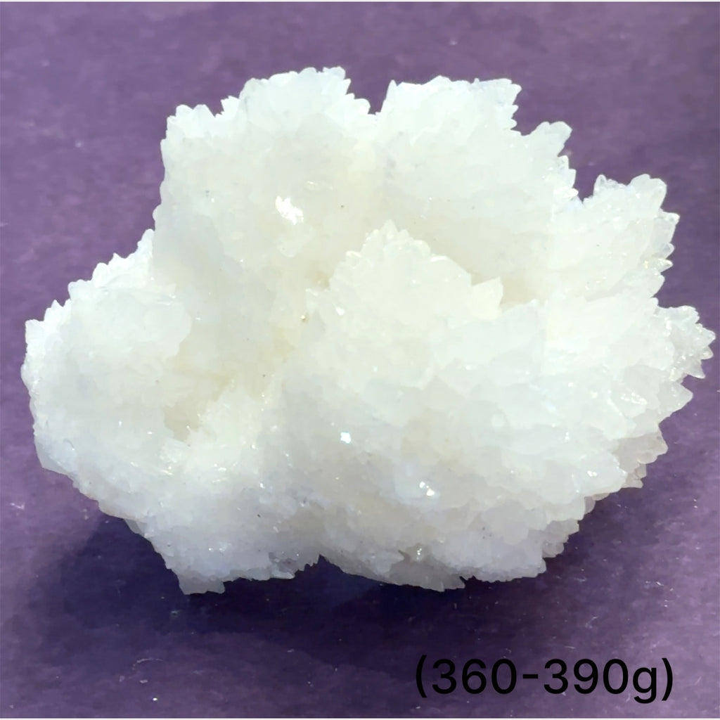 Close-up of White Aragonite cluster highlighting natural white crystal formations size (360-390g) on purple background front view.