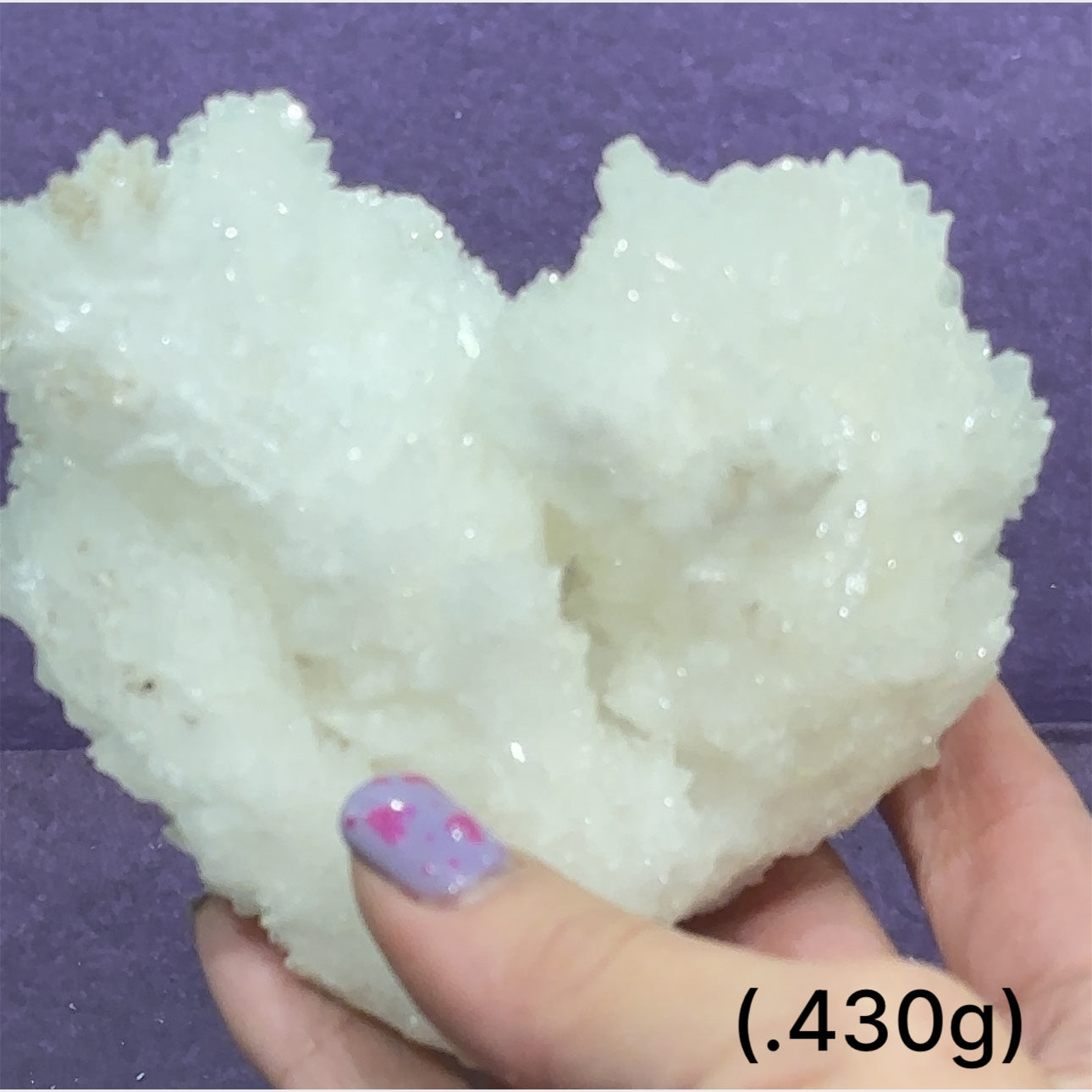 Close-up of White Aragonite cluster highlighting natural white crystal formations size (430g) on purple background front view.