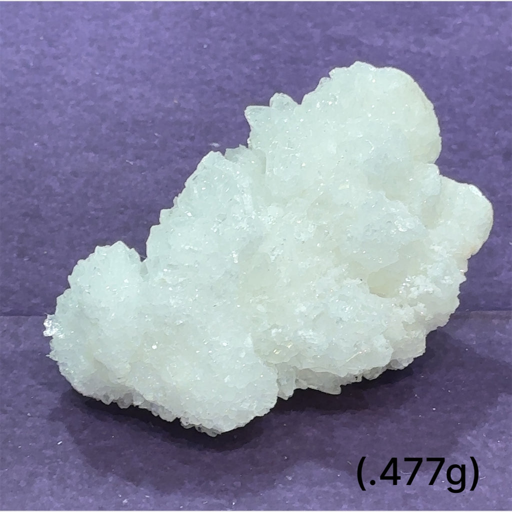 Close-up of White Aragonite cluster highlighting natural white crystal formations size (477g) on purple background front view.