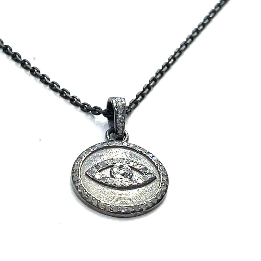 Close-up of diamond pavé Evil Eye pendant showing oxidized texture and detail on a white background long hanging overview.
