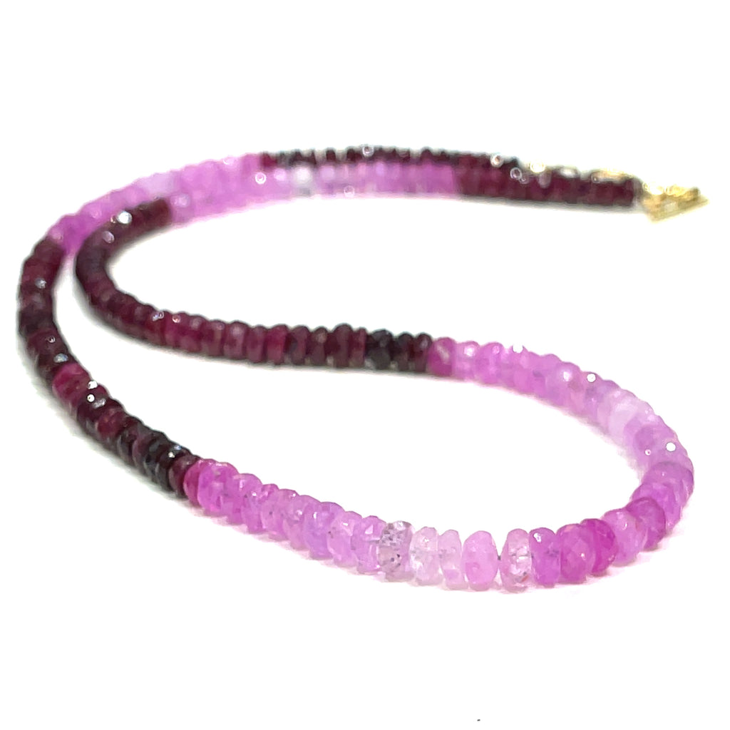 Close-up of faceted ruby roundel beads showing deep red brilliance. on a white background front, center long overview.