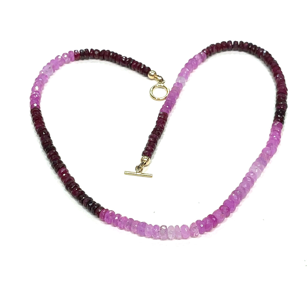 Close-up of faceted ruby roundel beads showing deep red brilliance. on a white background front, center overview.